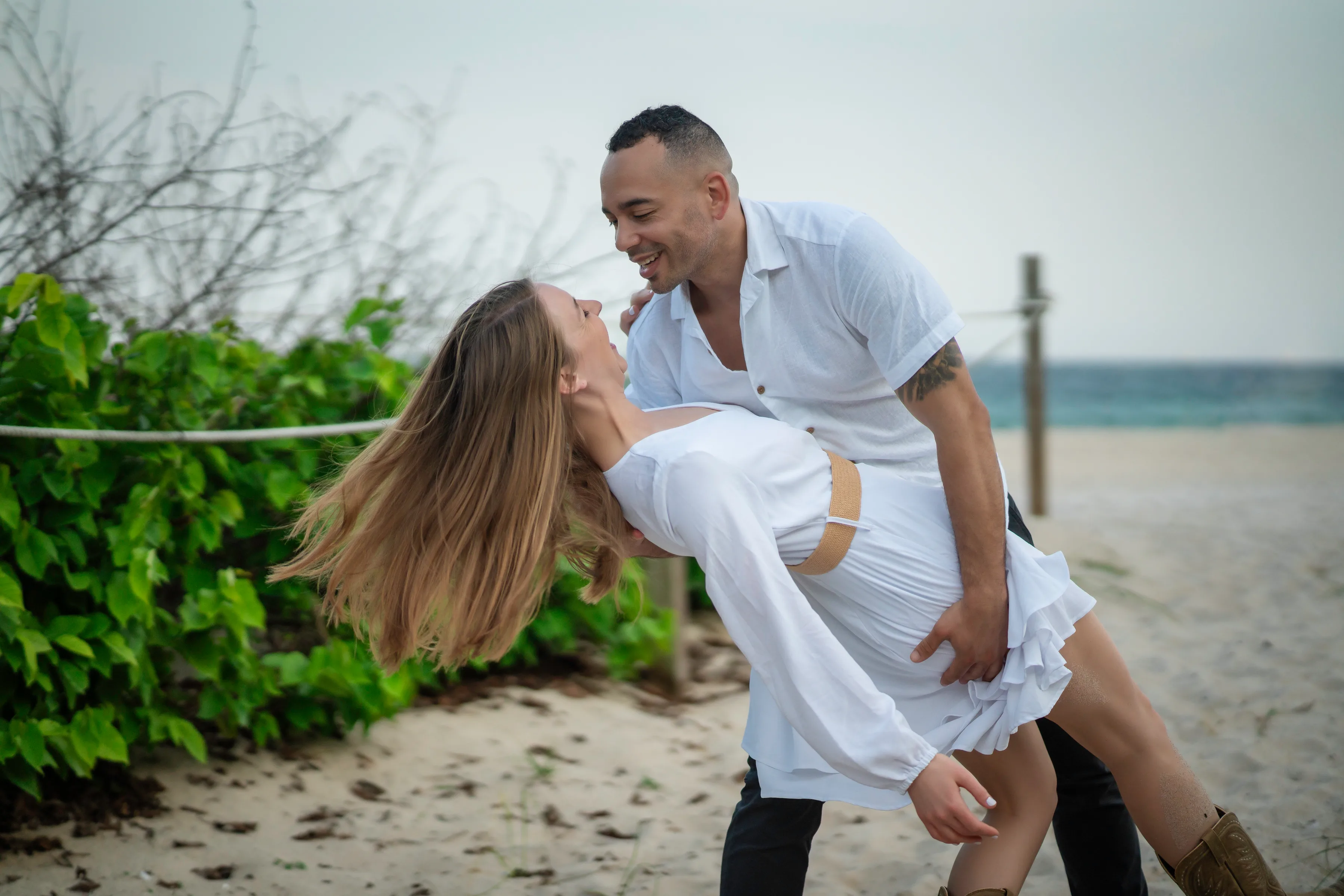 A couple sharing a supported dip beside a waterfront.