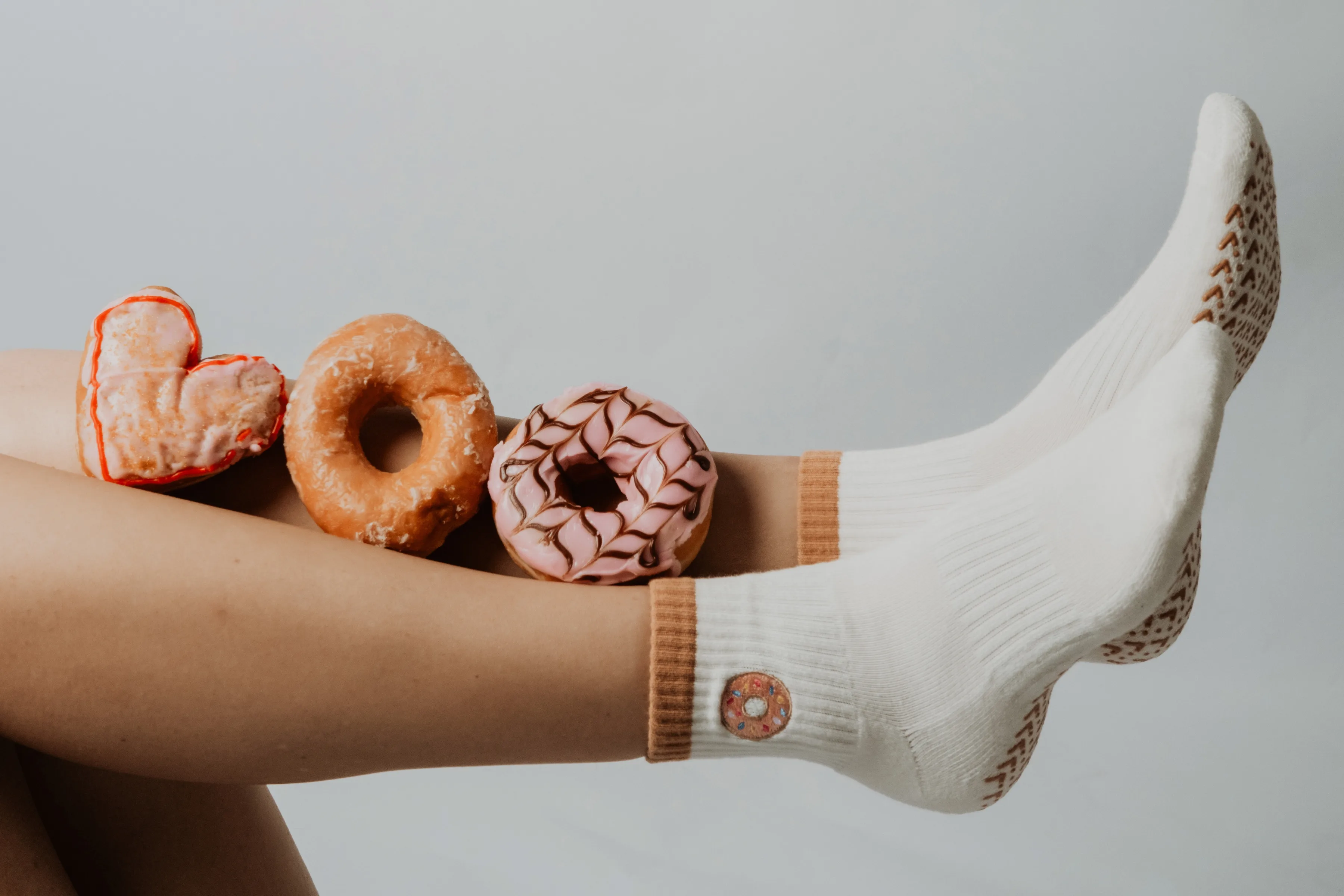 Socks styled with donuts against a neutral background.