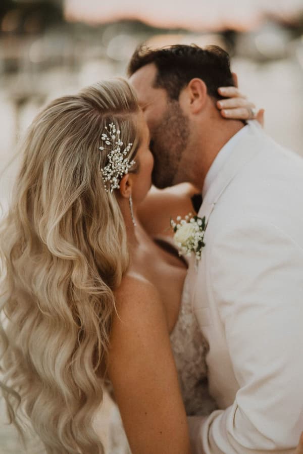 A man and a woman are kissing each other with the background being blurry.