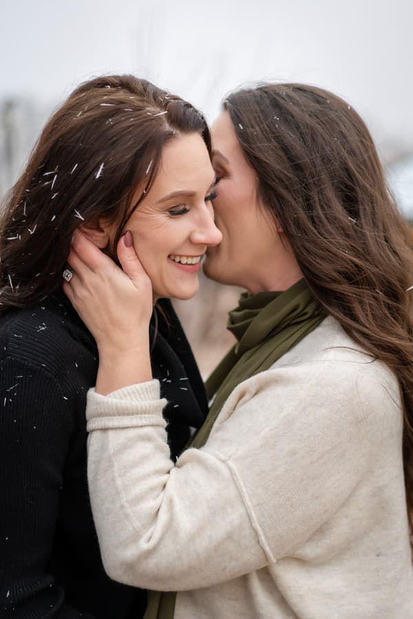 Two women are hugging each other with smiles on their faces.