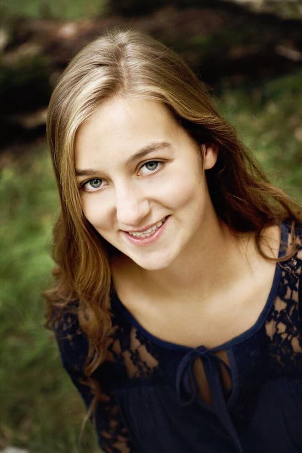 A young woman with blonde hair is smiling at the camera.